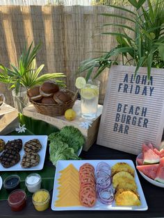 a table topped with plates of food next to a sign