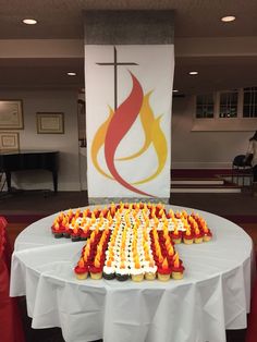 cupcakes arranged in the shape of a cross on top of a white table