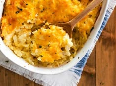 a casserole dish filled with mashed potatoes and topped with a wooden spoon