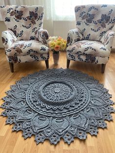 a living room with two chairs and a rug on the floor