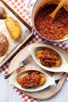 baked beans are in bowls on plates next to a tray with pastries and bread