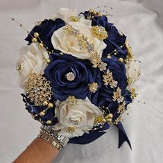 a bridal bouquet with blue and white flowers is shown in close up view on the bride's arm