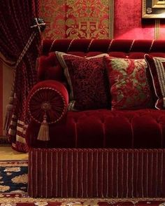 a red couch with many pillows on it