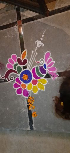 a colorful flower painted on the ground next to a cross