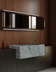 a bathroom with a marble sink and wooden walls