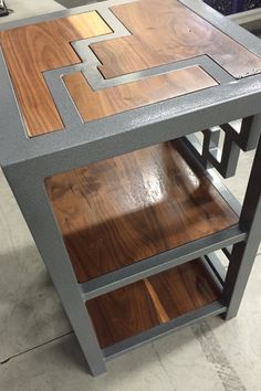 a table made out of wood and metal with geometric designs on the top, sitting in a shop