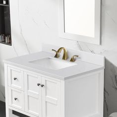 a white bathroom vanity with two golden faucets on it's sides and a mirror over the sink