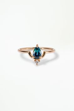 a gold ring with a blue topazte and two white diamonds on the side