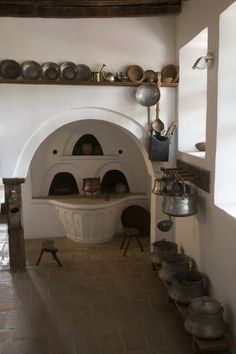 an old fashioned kitchen with pots and pans on the wall