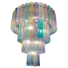 a multicolored glass chandelier hanging from a ceiling fixture on a white background