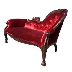 an old fashioned red velveted chair with ornate carvings on the armrests and back