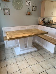 a kitchen table with benches in front of it and a clock on the wall behind it