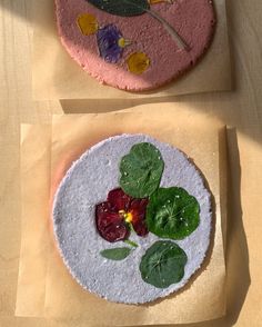 two cakes decorated with edible flowers and leaves