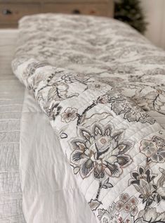 an unmade bed with a floral comforter on it