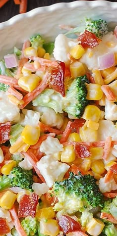 a salad with broccoli, corn and bacon on it is ready to be eaten