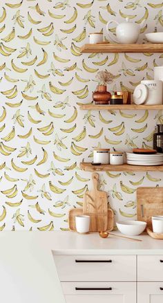 a kitchen with bananas on the wall next to bowls and cups in front of it