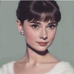 a woman with short hair wearing earrings and a white dress