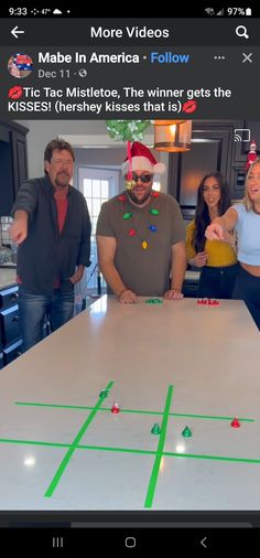 a group of people standing around a table with a christmas hat on top of it