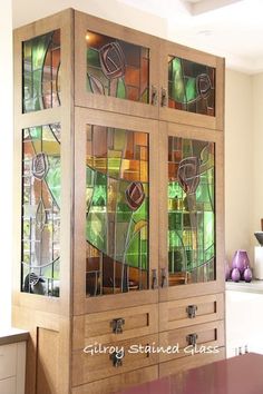 a wooden cabinet with stained glass doors and drawers