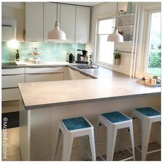 three stools sit at the center of a kitchen island