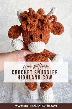 a hand holding a small crochet snuggler cow