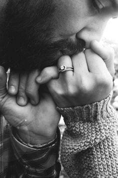 a man is holding his hand to his face while wearing a ring with a cross on it