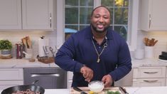 a man standing in front of a cutting board with food on it and a knife