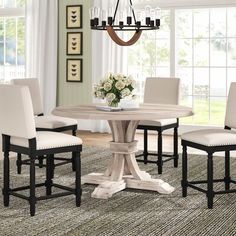 a dining room table and chairs with a chandelier hanging from the ceiling above it