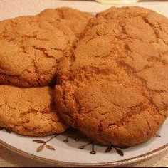 three cookies are on a plate with a jar of honey in the background