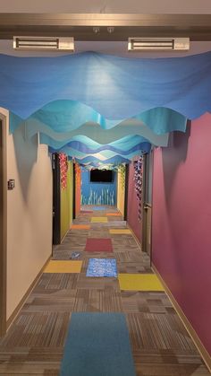 an empty hallway with colorful walls and carpet