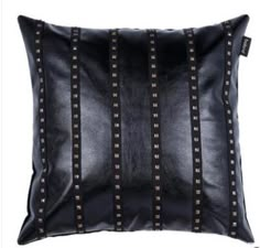 a black leather pillow with studding on the front and sides, sitting on a white background