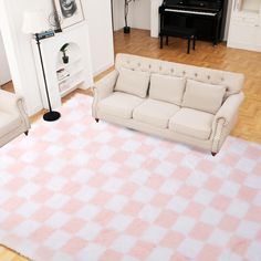 a living room with a checkered rug and white couches in front of a piano