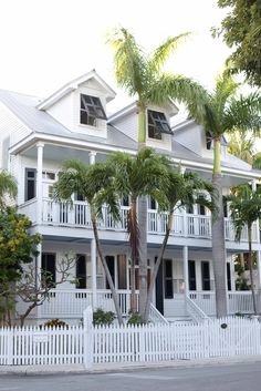 a white house with palm trees in front of it