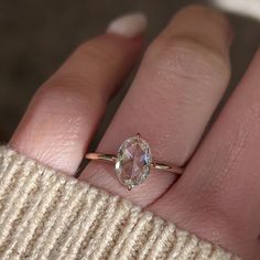 a woman's hand with a ring on it and a diamond in the middle