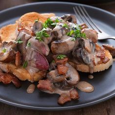 a close up of a plate of food with meat and mushrooms on toasted bread