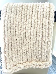 a close up of a chair cushion with a white blanket on it's back