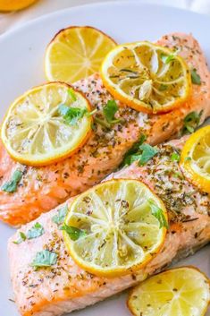 salmon with lemons and herbs on a white plate