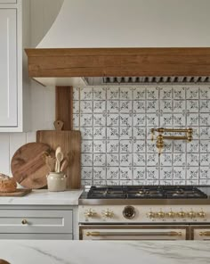 a stove top oven sitting inside of a kitchen next to wooden cutting boards and utensils