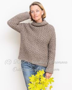 a woman holding a vase with yellow flowers in it and wearing a sweater over her shoulders