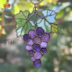 a stained glass grape ornament hanging from a tree