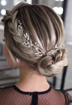 a woman with blonde hair in a low bun wearing a crystal headpiece and black mesh top