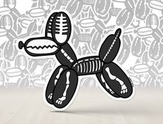 a black and white balloon dog with a football on it's back sitting in front of a wall