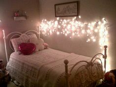 a white bed topped with lots of lights next to a night stand