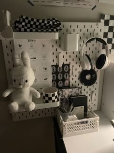 a stuffed animal sitting on top of a desk next to headphones and other items