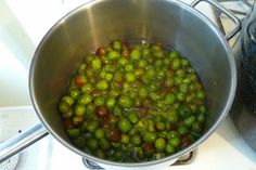 a metal bowl filled with green peas on top of a stove