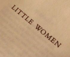 the word little women written on an old book