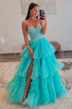 a woman taking a selfie wearing a blue dress with ruffles on it