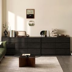 a living room filled with furniture and a coffee table in front of a wall mounted clock