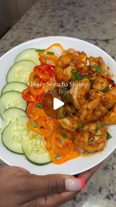 a person holding a white plate with food on it and the words honey sriraca shrimp