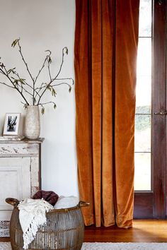 a vase with some flowers in it sitting on a table next to a dresser and window